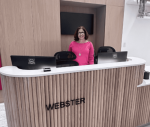 Front desk at Webster Apartments in Downtown Brooklyn with a welcoming staff member, offering a modern and stylish lobby for residents.