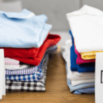 wo neatly folded piles of clothing on a table labeled 'Keep' and 'Donate,' representing a mindful approach to decluttering and spring cleaning.