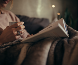 Female Reading Book on Bed at Night