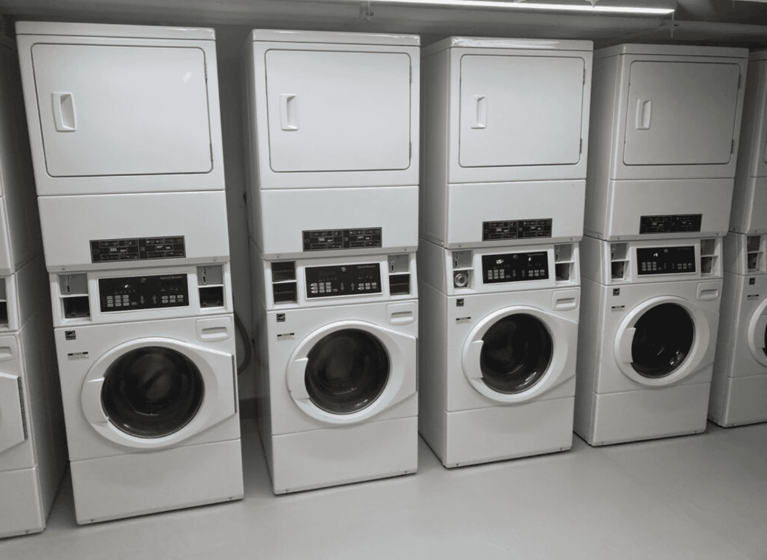 Complimentary laundry facilities at Webster Apartments, featuring multiple washer and dryer units for residents’ convenience, available 24/7