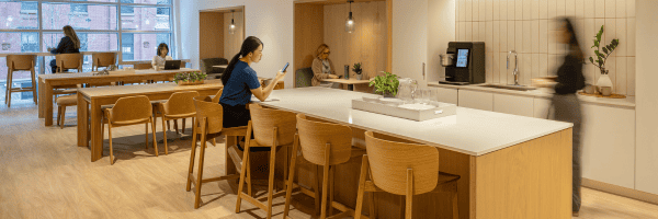 Residents enjoying the communal workspace and kitchen area at Webster Apartments in Downtown Brooklyn, designed for relaxation and productivity with modern amenities.