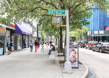 The vibrant Duffield Street in Downtown Brooklyn, with local shops, tree-lined sidewalks, and a bustling atmosphere, located just steps away from Webster Apartments.