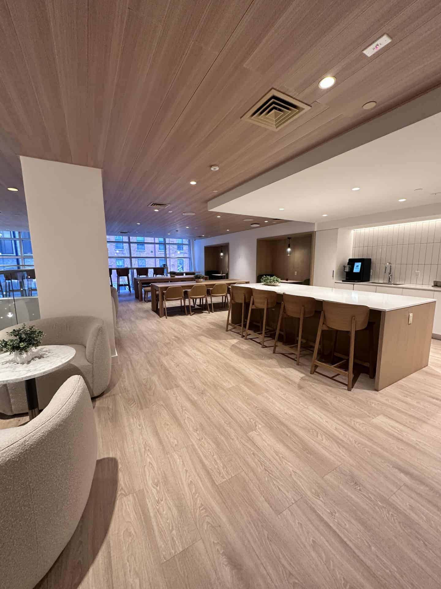 Modern lounge area at Webster Apartments featuring stylish seating and a spacious kitchen bar, perfect for relaxing or socializing in Downtown Brooklyn.
